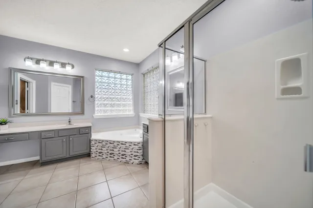 a bathroom with a granite countertop sink a mirror and a bathtub