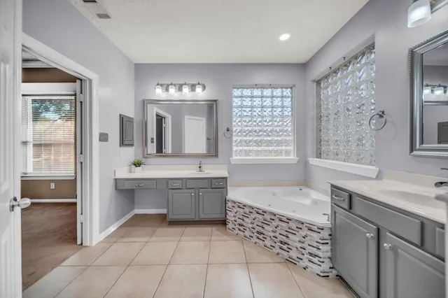 a large bathroom with a tub sink shower and mirror