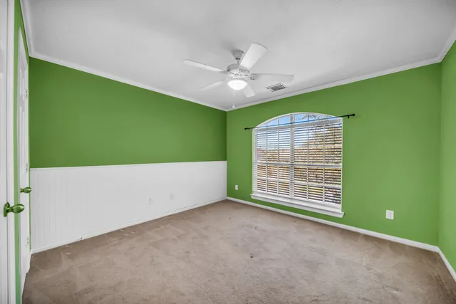 a view of an empty room with a window and a ceiling fan