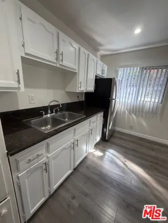 a kitchen with granite countertop a sink and cabinets