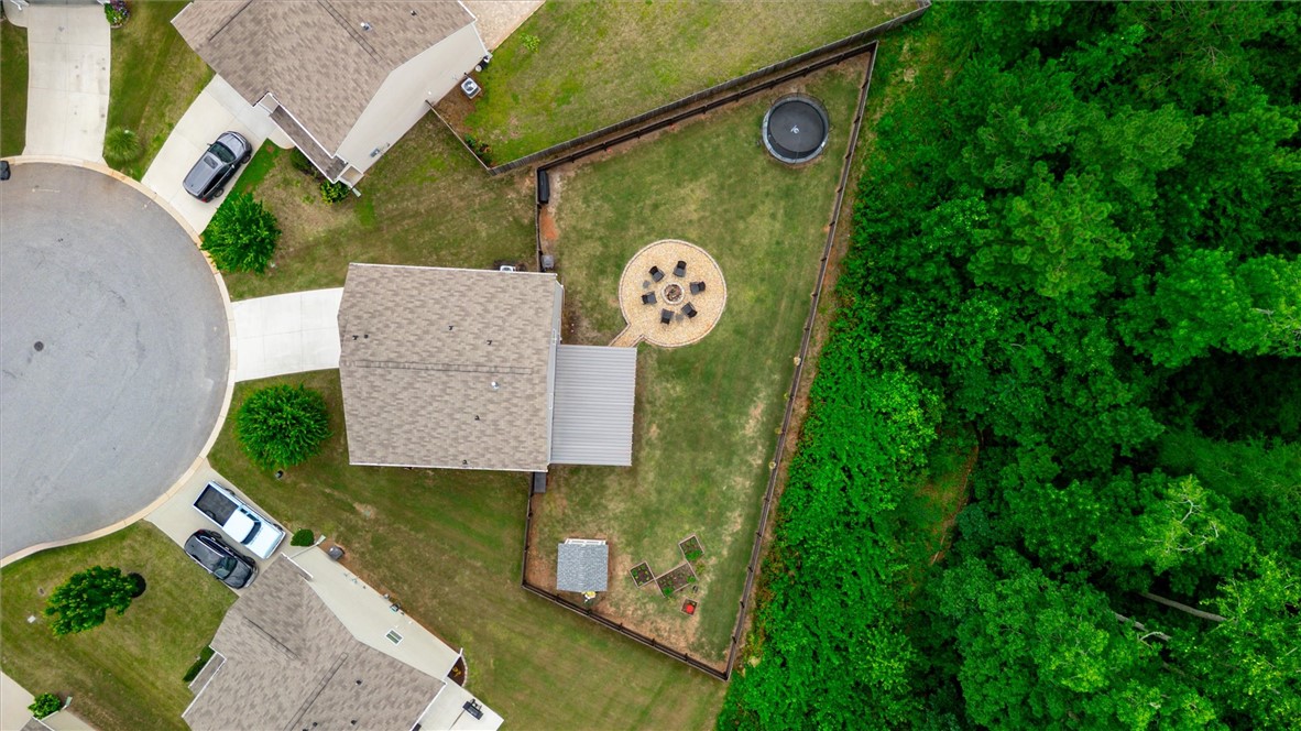 34 Karkinnen Court Pendleton, SC 29670 - Photo 31 of 36 An aerial perspective showcases the spacious backyard with a cozy fire pit area and a vibrant tree line for privacy.