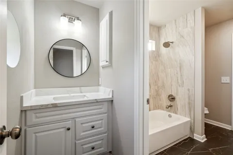 a bathroom with a tub sink and mirror