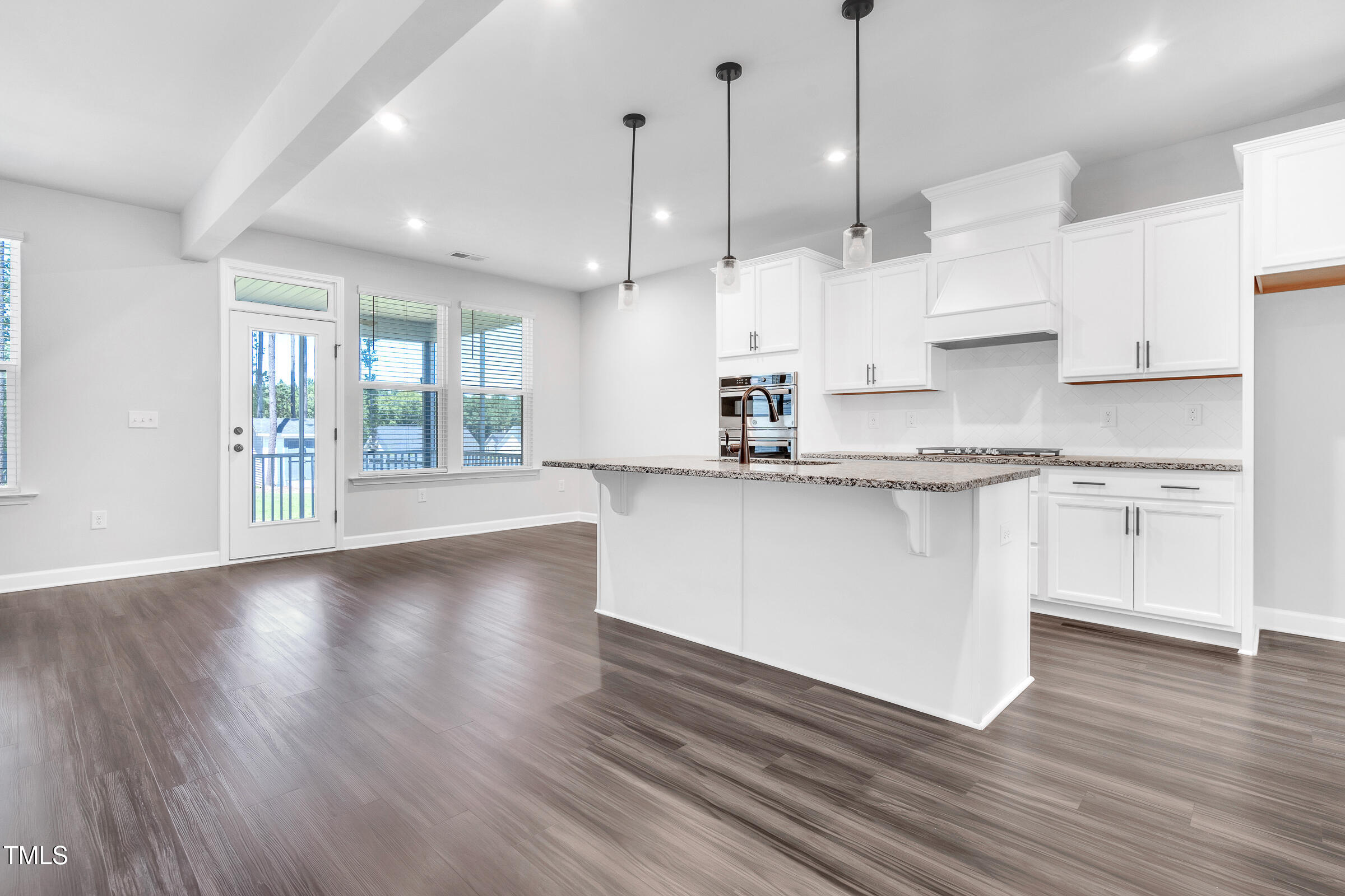 61 Cascade Place Clayton, NC 27527 - Photo 12 of 33 a large white kitchen with kitchen island a stove a sink dishwasher and white cabinets with wooden floor