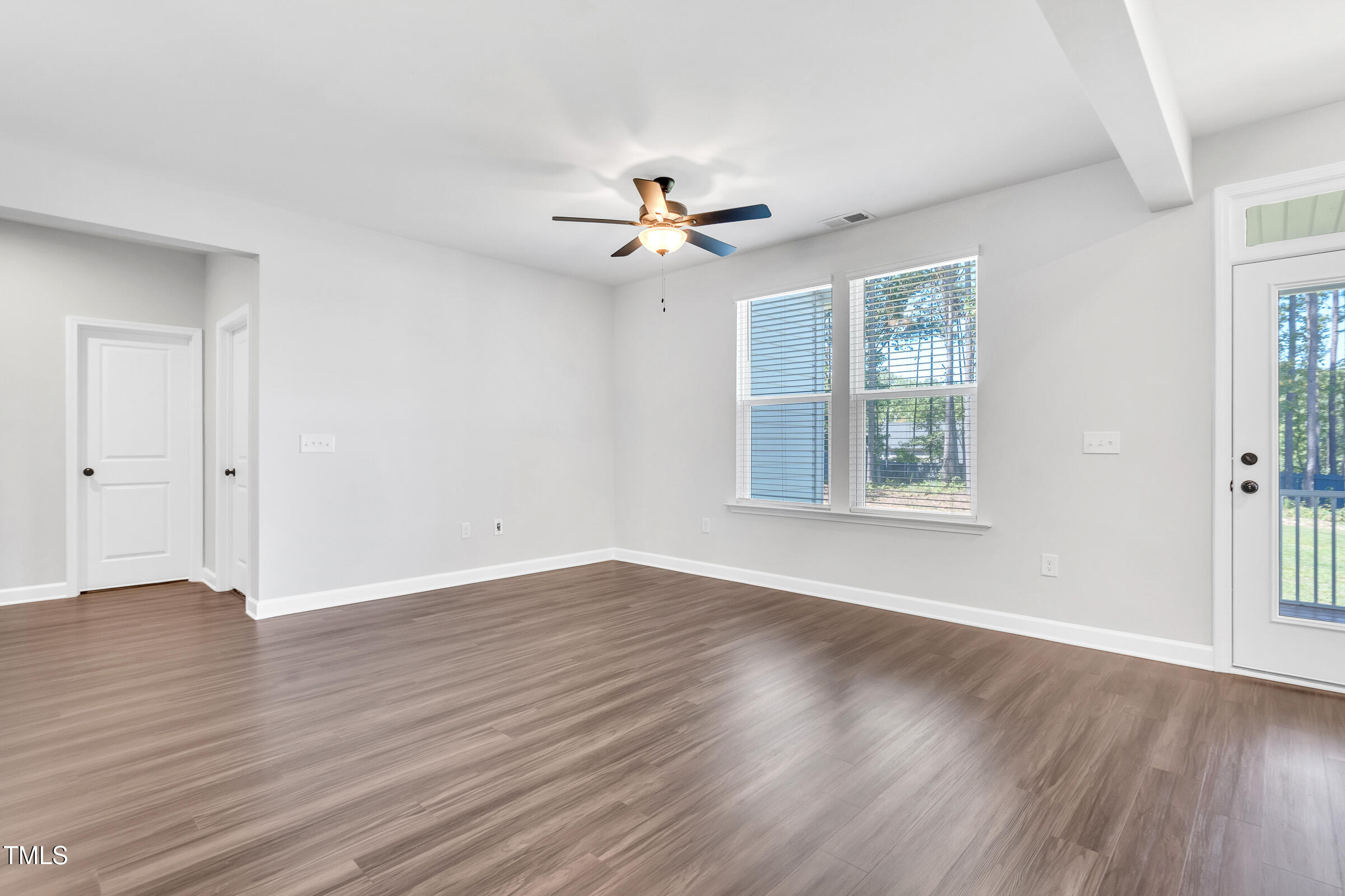 61 Cascade Place Clayton, NC 27527 - Photo 13 of 33 an empty room with wooden floor ceiling fan with window