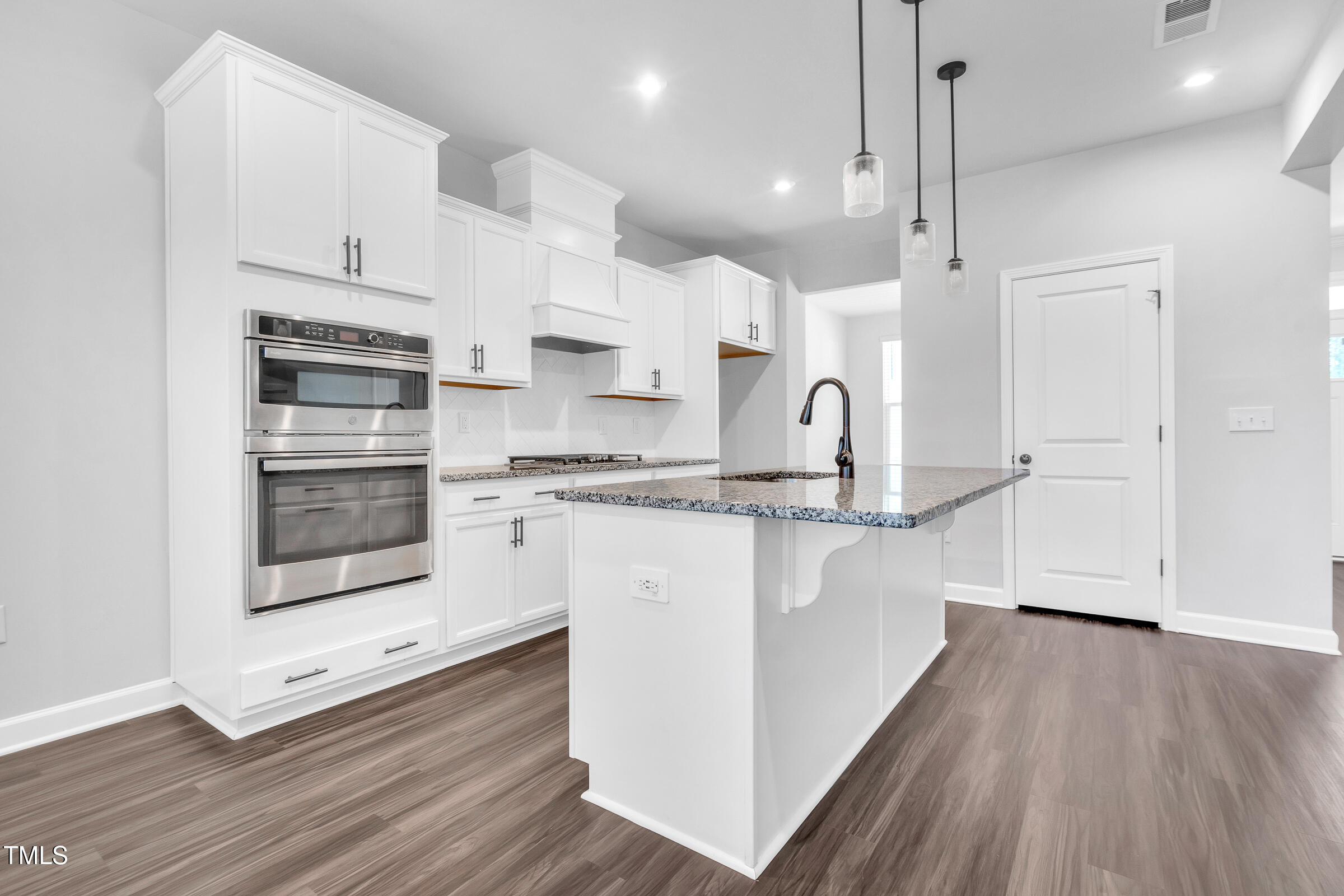 61 Cascade Place Clayton, NC 27527 - Photo 7 of 33 a kitchen with stainless steel appliances a stove a sink a refrigerator and white cabinets with wooden floor