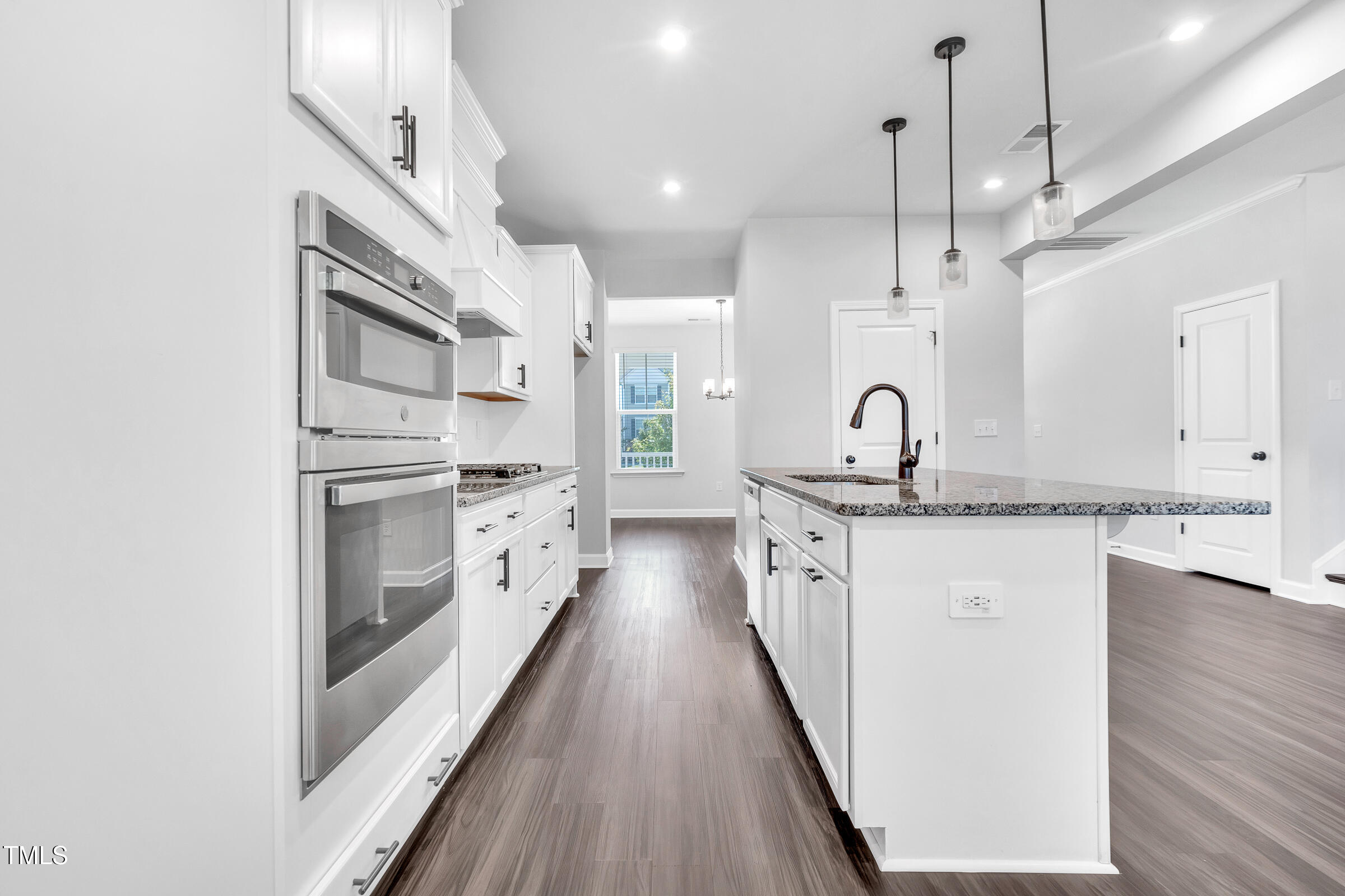 61 Cascade Place Clayton, NC 27527 - Photo 8 of 33 a kitchen with white cabinets appliances and a chandelier