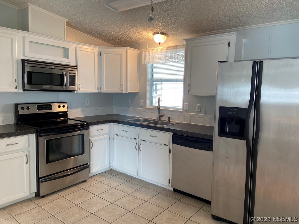 626 Starboard Avenue Edgewater, FL 32141 - Photo 14 of 38 a kitchen with granite countertop white cabinets and stainless steel appliances