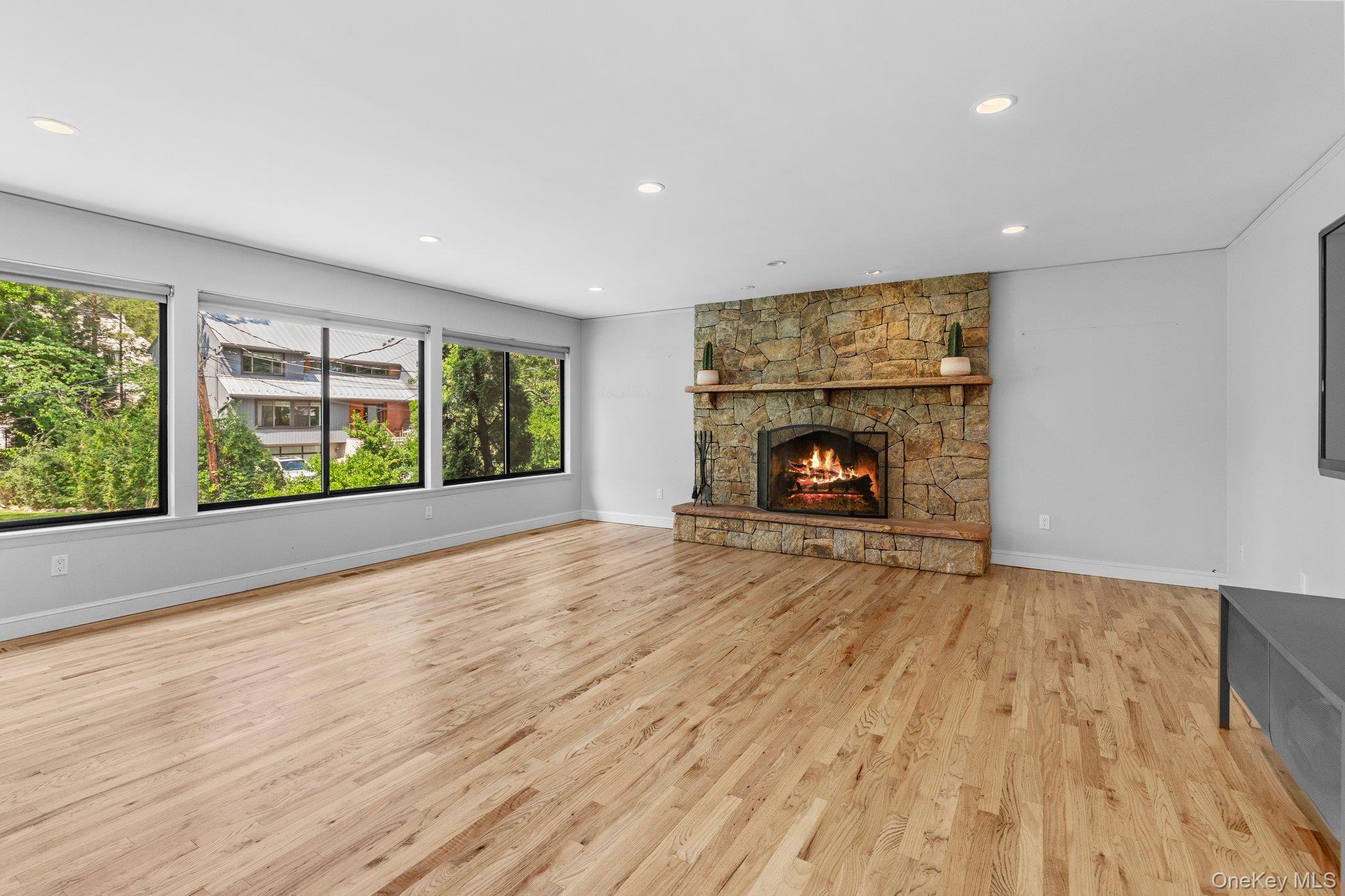 27 Stone Cabin Road New Rochelle, NY 10801 - Photo 5 of 24 Unfurnished living room featuring baseboards, a fireplace, light wood-style floors, and recessed lighting