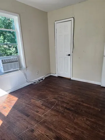 a view of room with window and wooden floor