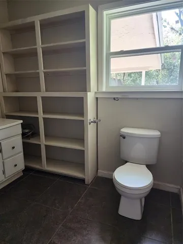 a white toilet sitting next to a window