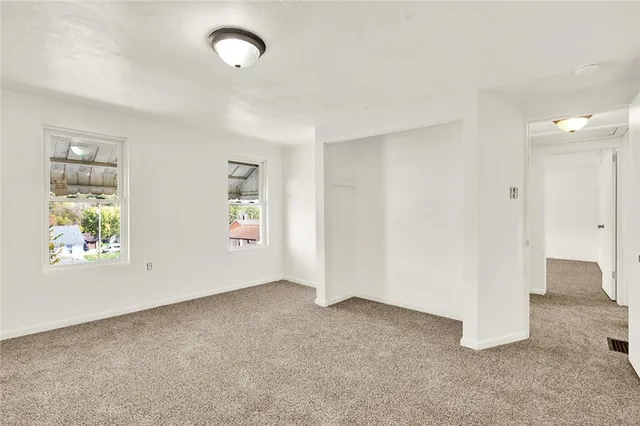 an empty room with windows and closet