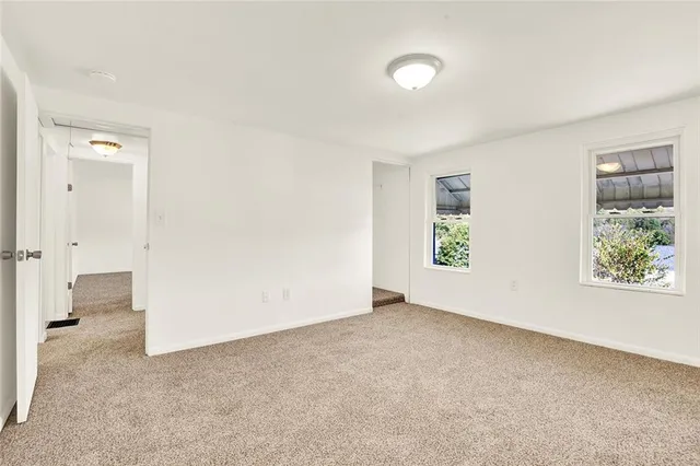 an empty room with windows and closet