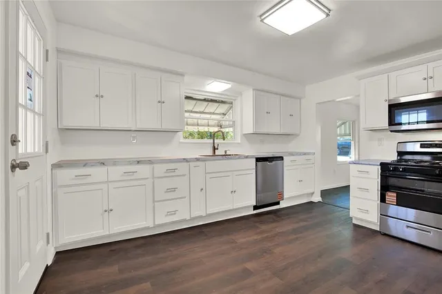a kitchen with stainless steel appliances white cabinets and a sink