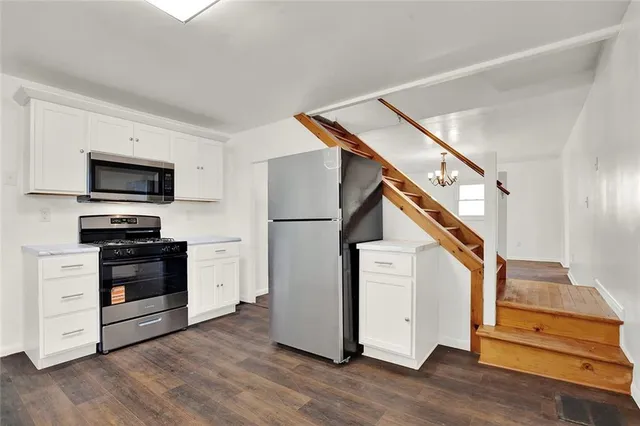 a view of kitchen with wooden floor and electronic appliances