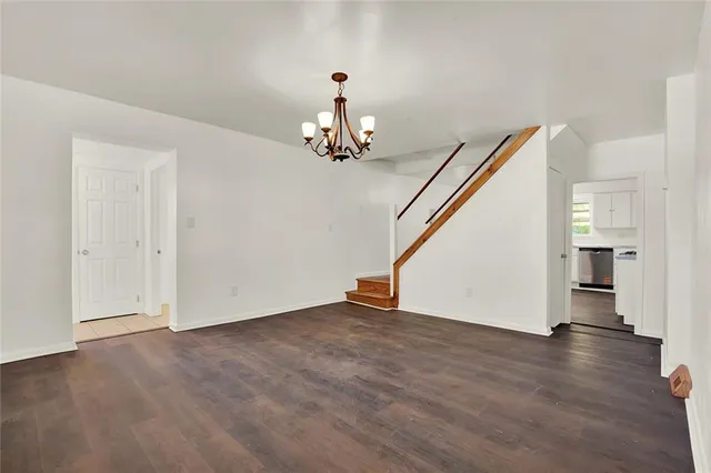 an empty room with wooden floor and stairs