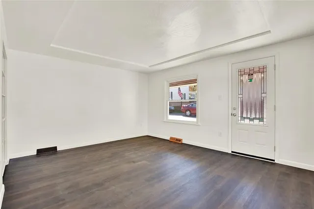 an empty room with wooden floor and window