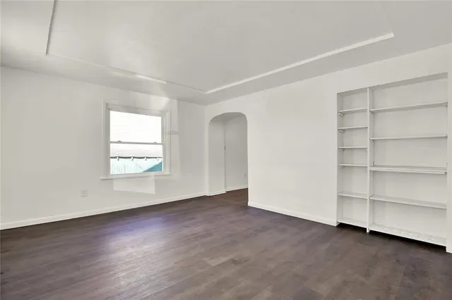 an empty room with a fireplace and cabinet