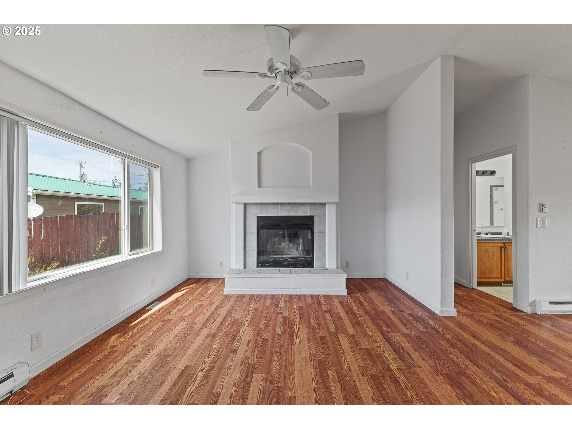1829 East Willow Street Myrtle Point, OR 97458 - Photo 12 of 37 a view of an empty room with a fireplace and wooden floor