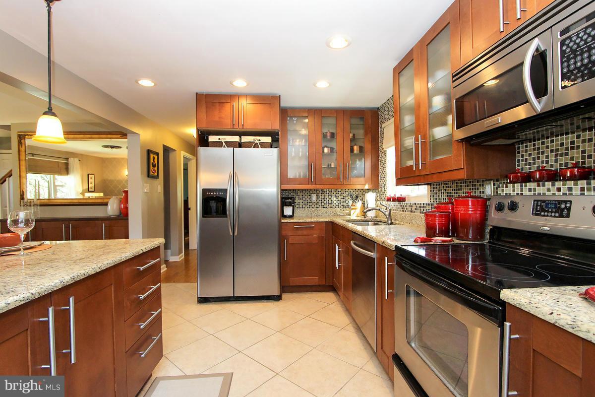 12701 Holdridge Road Silver Spring, MD 20906 - Photo 10 of 30 a kitchen with stainless steel appliances granite countertop a sink a stove and a refrigerator
