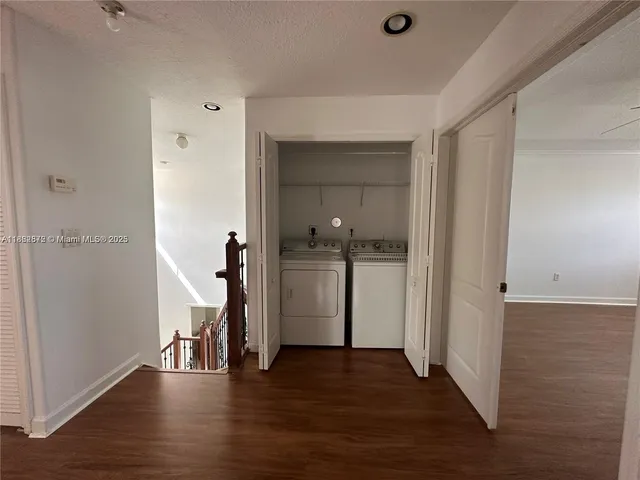 a view of a hallway with wooden floor and closet