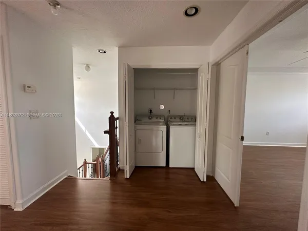 a view of a hallway with wooden floor and closet