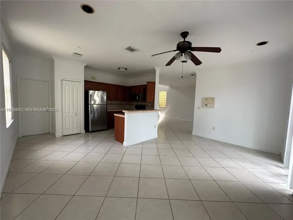 a kitchen with stainless steel appliances kitchen island granite countertop a refrigerator and a stove top oven