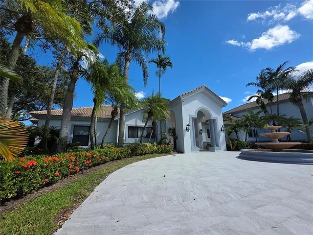 a view of a house with a yard and potted plants