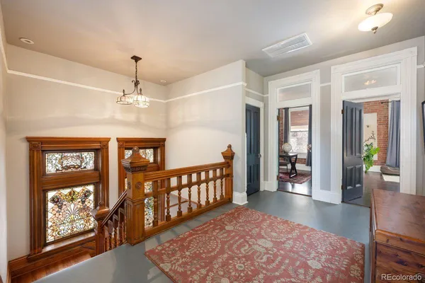 a view of a hallway with wooden floor and windows