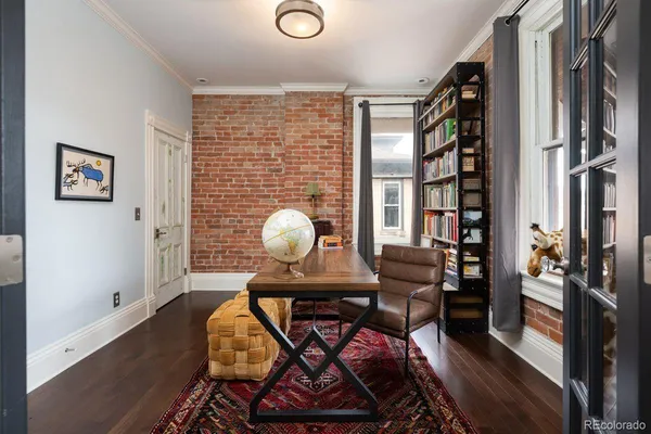 a view of a workspace with furniture and a large window