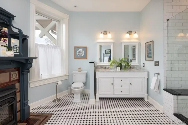 a bathroom with a double vanity sink a mirror and a toilet