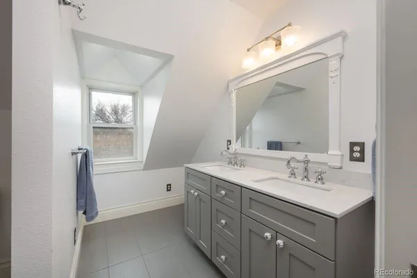 a bathroom with a sink a vanity a window and a mirror