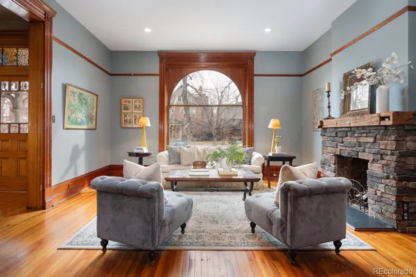a living room with fireplace furniture and a large window