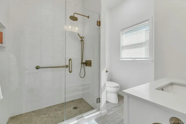 a bathroom with a granite countertop sink toilet and shower