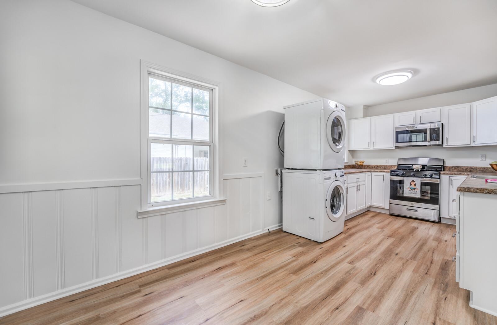 5600 Manley Road Memphis, TN 38120 - Photo 13 of 31 a kitchen with stainless steel appliances granite countertop a refrigerator a stove a sink and white cabinets with wooden floor