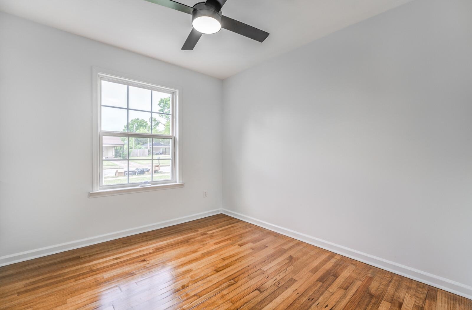 5600 Manley Road Memphis, TN 38120 - Photo 23 of 31 an empty room with wooden floor fan and windows
