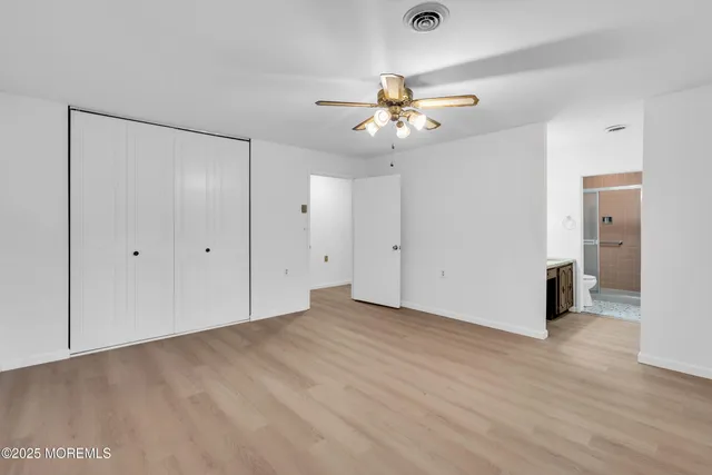 a view of an empty room with closet and a chandelier fan