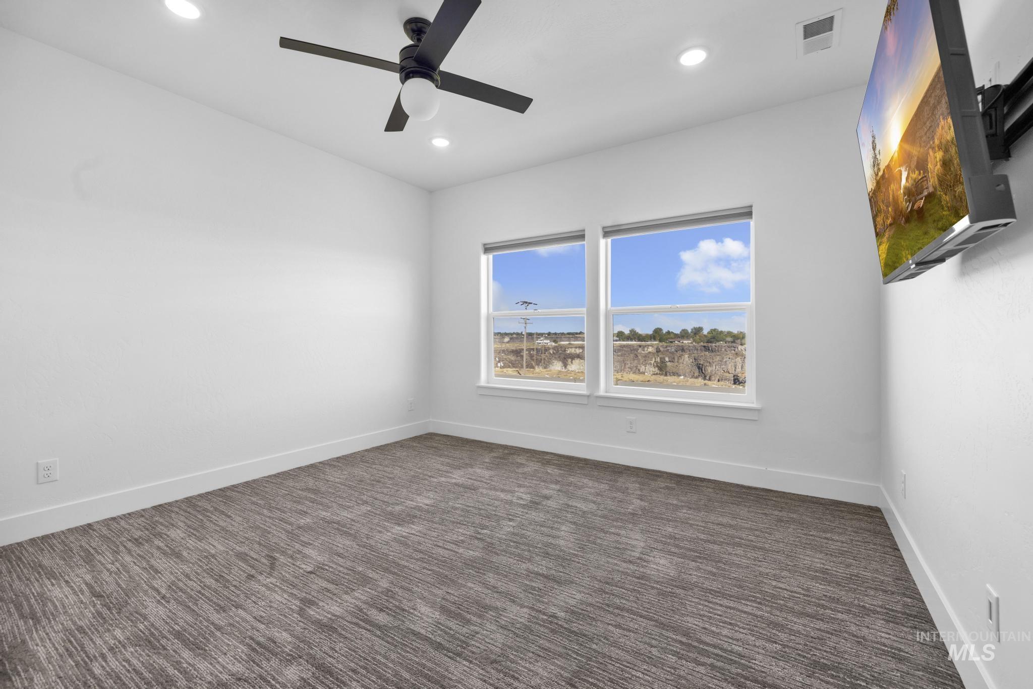 4280 Rim Vista Road Filer, ID 83328 - Photo 36 of 50 Dual windows with white trim, contemporary ceiling fan, recessed lighting, and patterned carpet flooring
