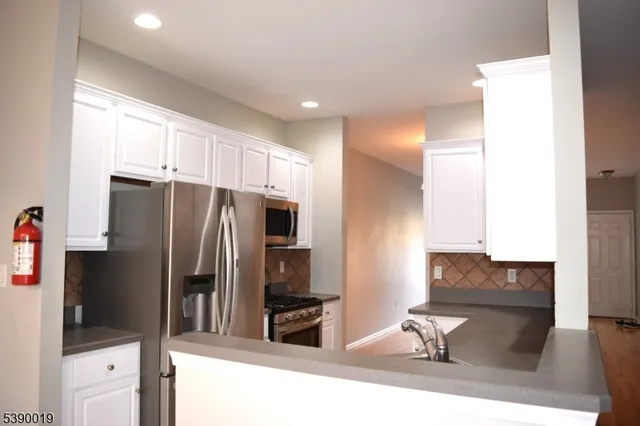 a kitchen with stainless steel appliances a refrigerator and a stove top oven