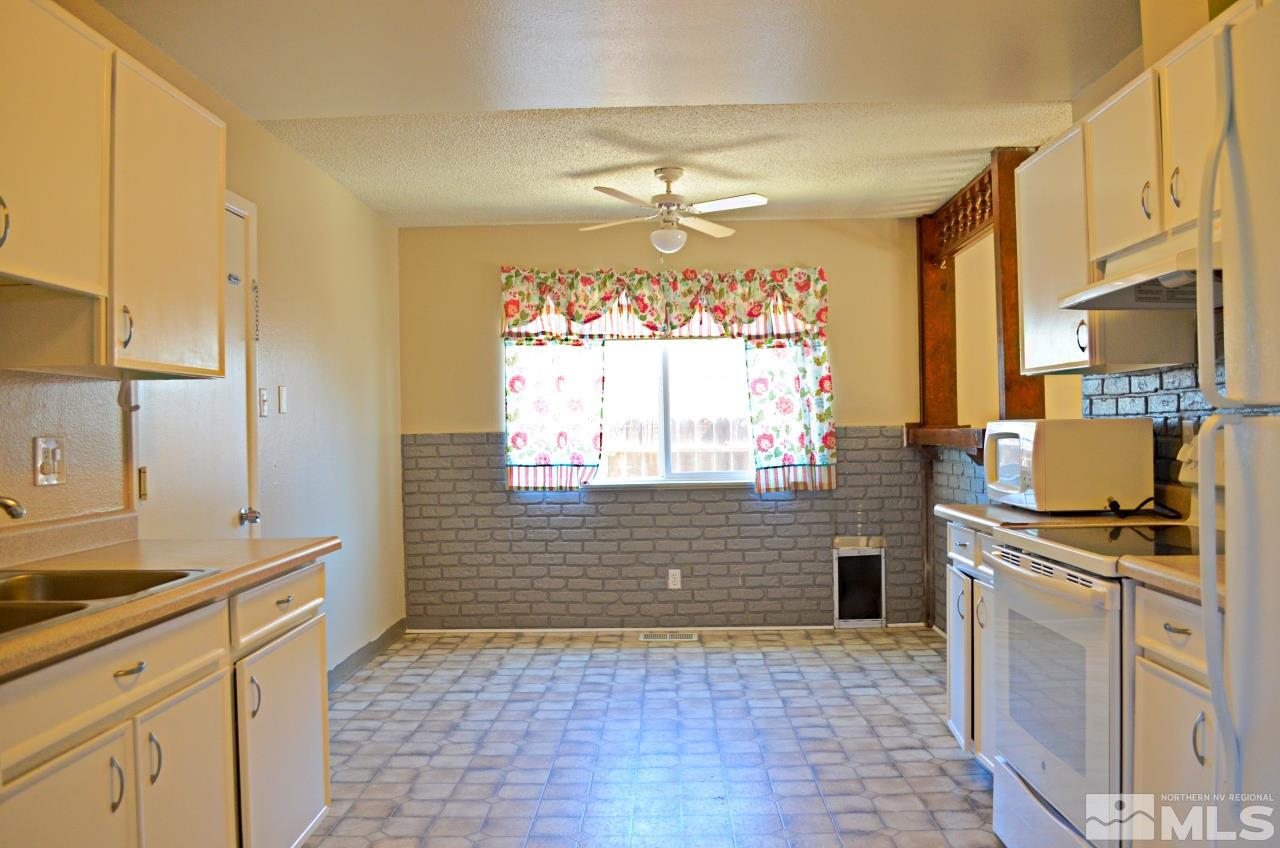 1385 Akard Drive Reno, NV 89503 - Photo 3 of 10 a kitchen with granite countertop a stove a sink and a refrigerator