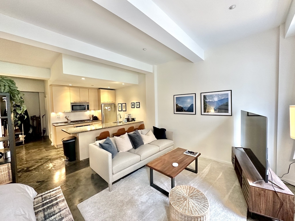 a living room with furniture rug and wooden floor