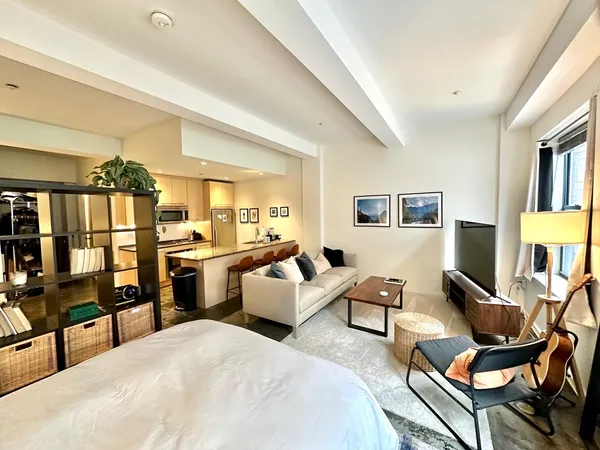 a living room with furniture kitchen view and a window