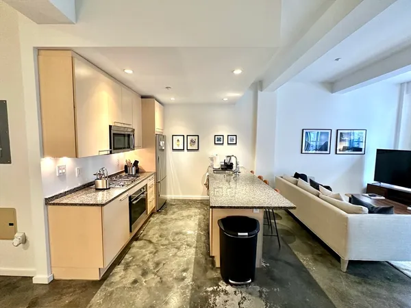 a living room with granite countertop furniture and kitchen view