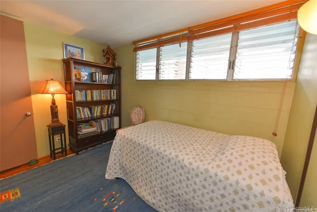 a bedroom with a bed and a book shelf