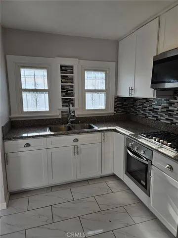 a kitchen with stainless steel appliances granite countertop a sink and a stove