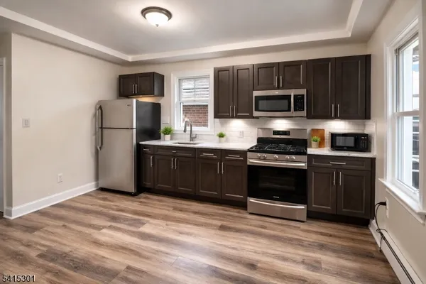 a kitchen with granite countertop a refrigerator and a stove top oven
