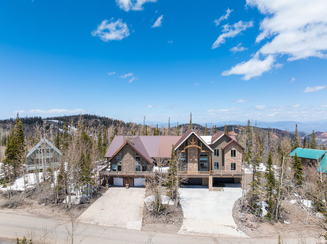 382 Ridgeview Street, Unit 8 & 9 Brian Head, UT 84719 - Photo 7 of 52 Stone and stucco multi-level residence with a multi-gabled metal roof, elevated deck, and a multi-car garage