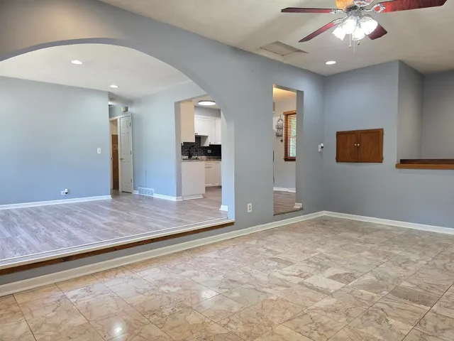 an empty room with wooden floor and mirror