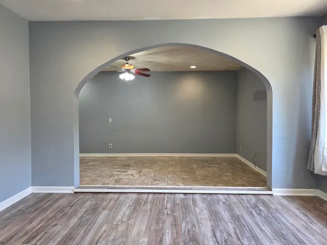 an empty room with wooden floor and door