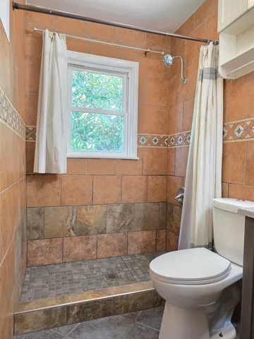 a bathroom with a sink a toilet and shower curtain