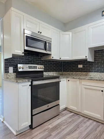 a kitchen with stainless steel appliances granite countertop a stove microwave and oven